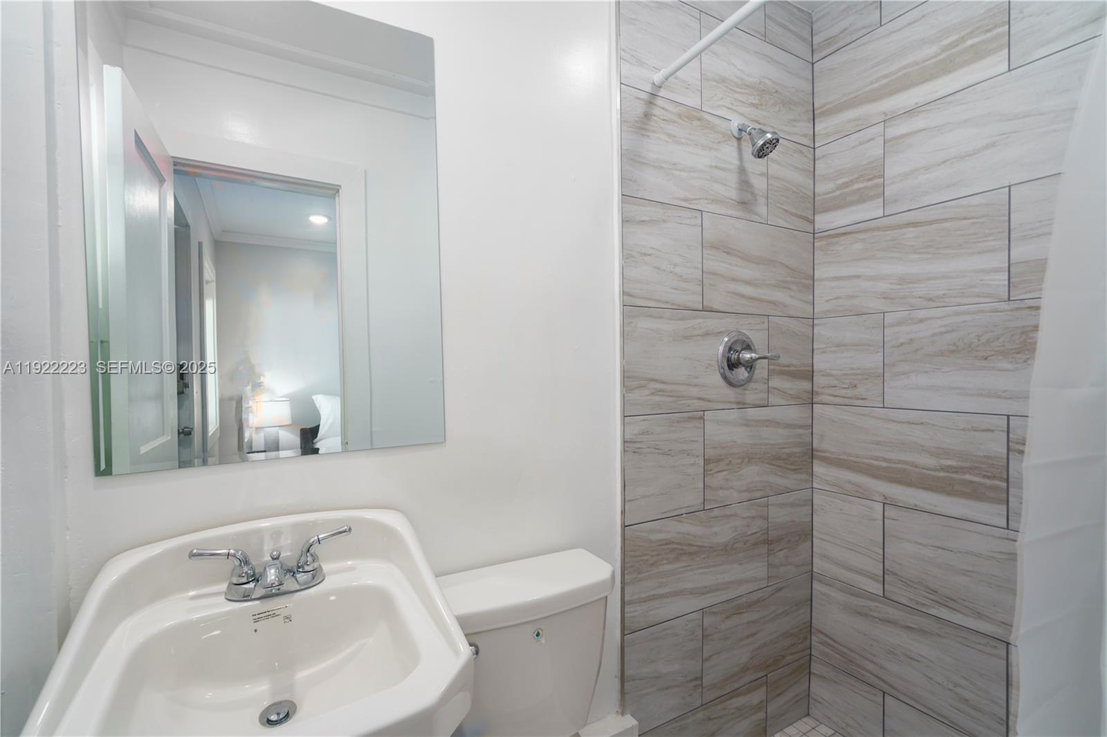 17784 Front Beach Road, Unit 10 Panama City, FL 32413 - Photo 6 of 12 a bathroom with a sink a toilet and shower