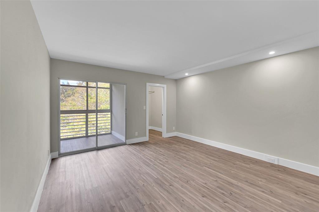 Lucaya Village Condominiums Coconut Creek, FL 33066 - Photo 11 of 28 a view of an empty room with wooden floor and a window