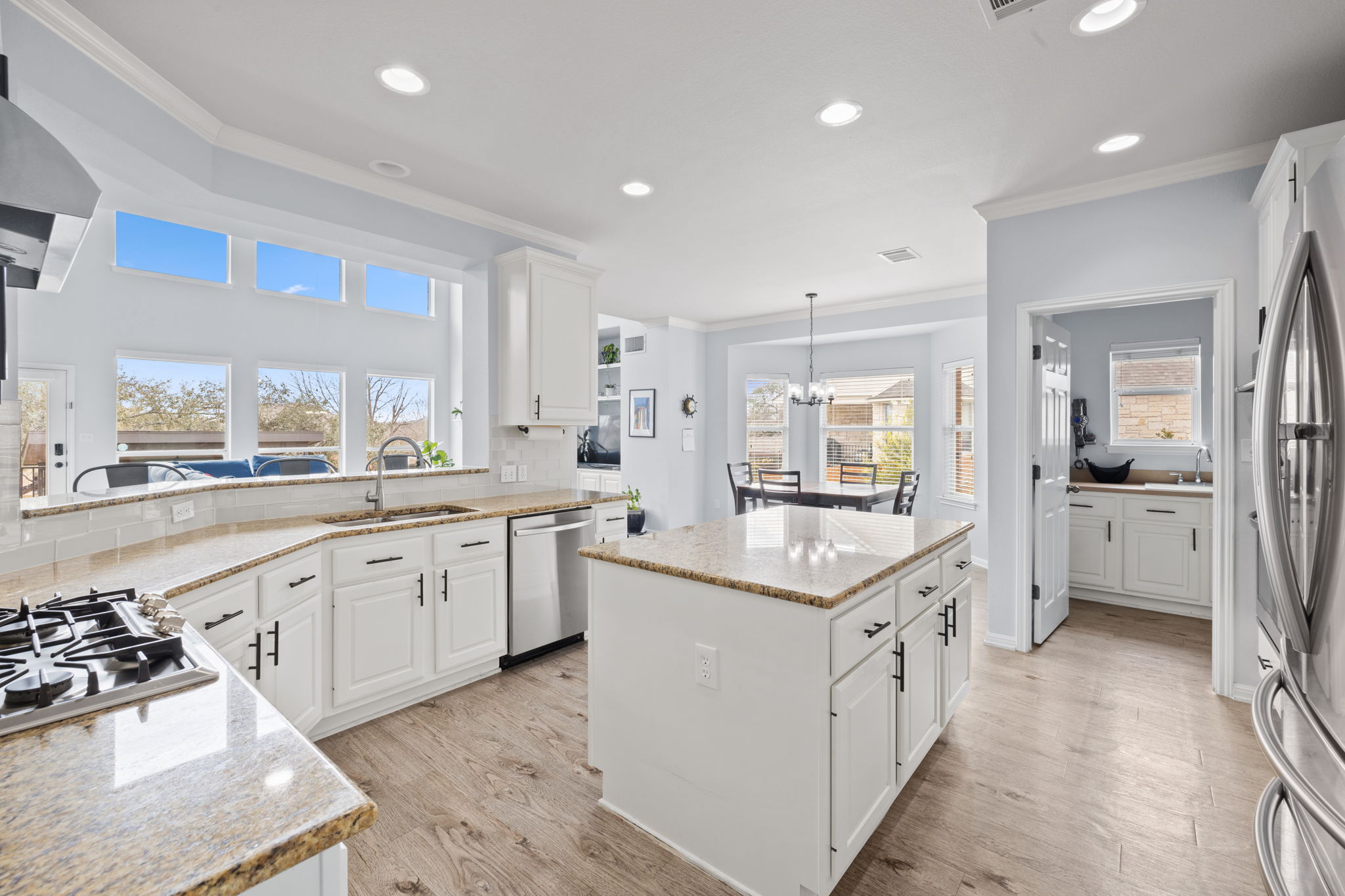 136 Eaton Lane Austin, TX 78737 - Photo 11 of 40 a large white kitchen with lots of counter space a sink appliances and a large window