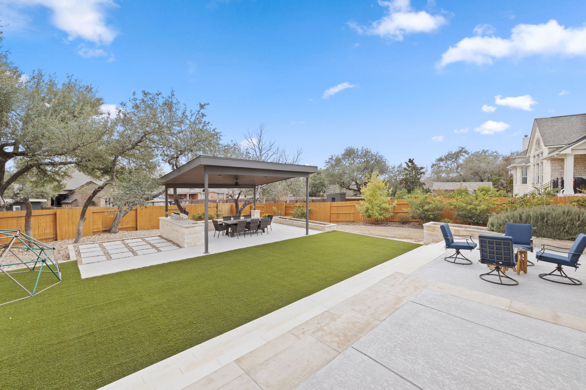 136 Eaton Lane Austin, TX 78737 - Photo 34 of 40 a view of a patio with a table and chairs under an umbrella