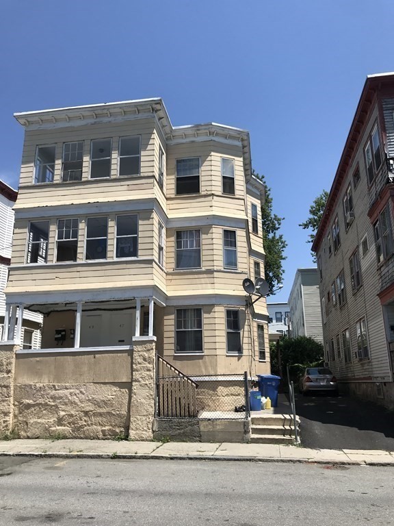 47-49 Juniper Street Lawrence, MA 01841 - Photo 2 of 4 a front view of a house with a yard