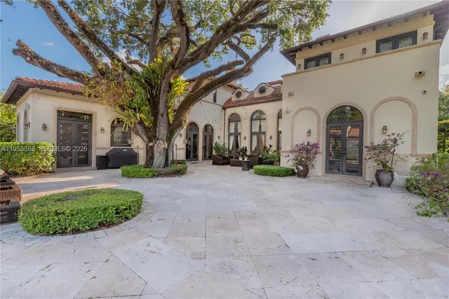 a view of a white house with a yard and plants