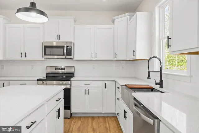a kitchen with stainless steel appliances granite countertop a sink and a stove