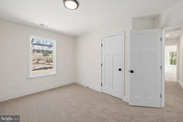 an empty room with windows and closet
