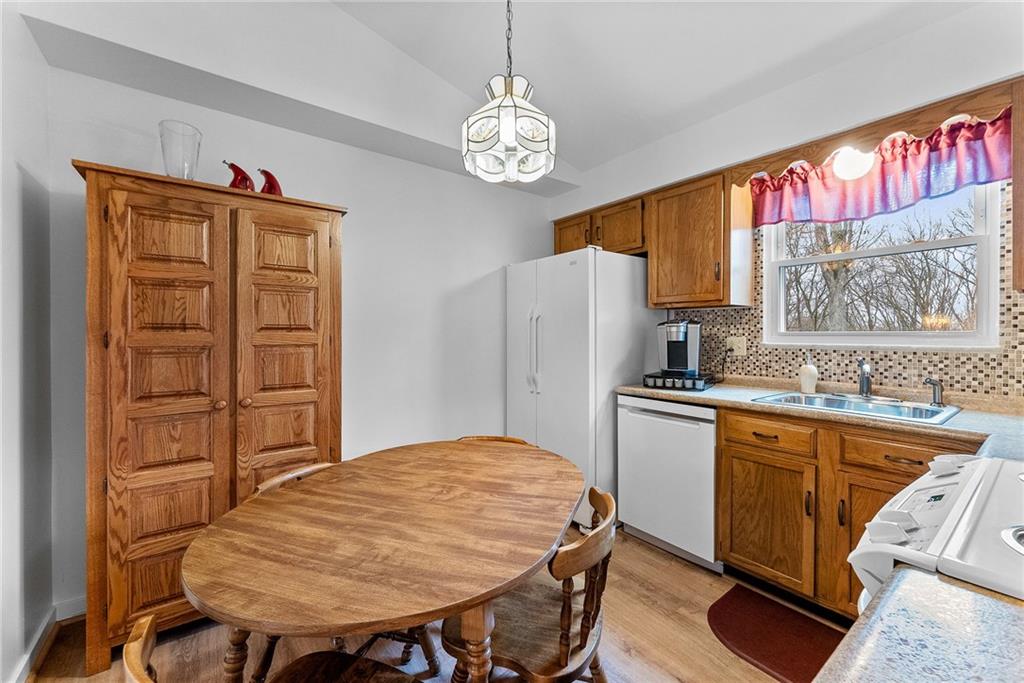 1257 Highway 989 Rochester, PA 15074 - Photo 8 of 40 a kitchen with stainless steel appliances granite countertop a refrigerator a sink dishwasher a dining table and chairs with wooden floor