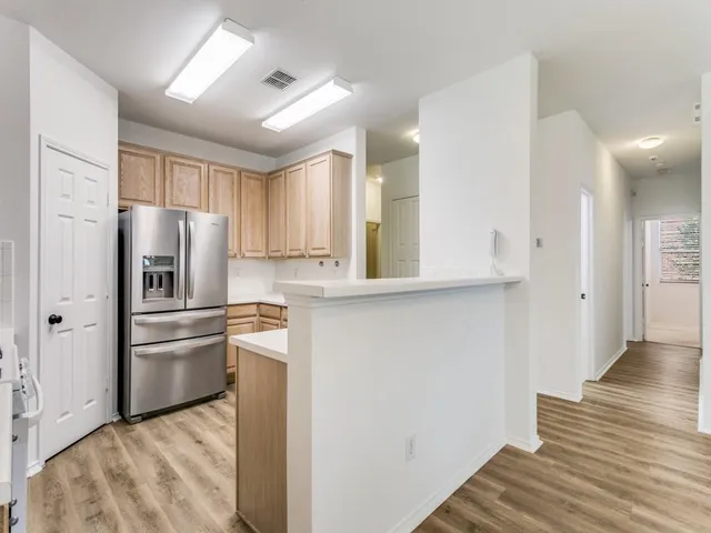 a kitchen with stainless steel appliances granite countertop a refrigerator and a stove