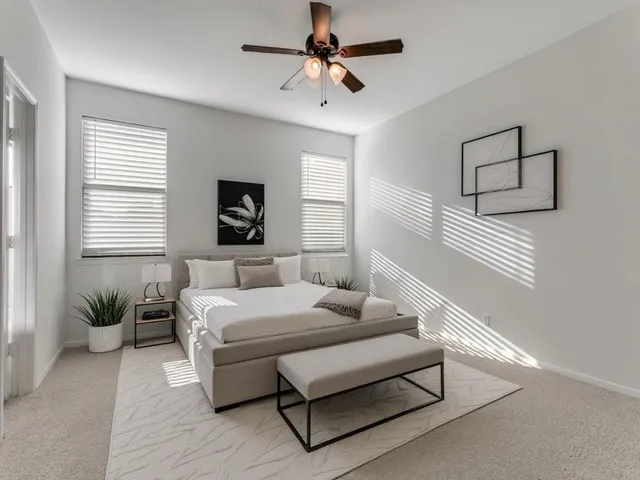 a bedroom with a bed chandelier and a window
