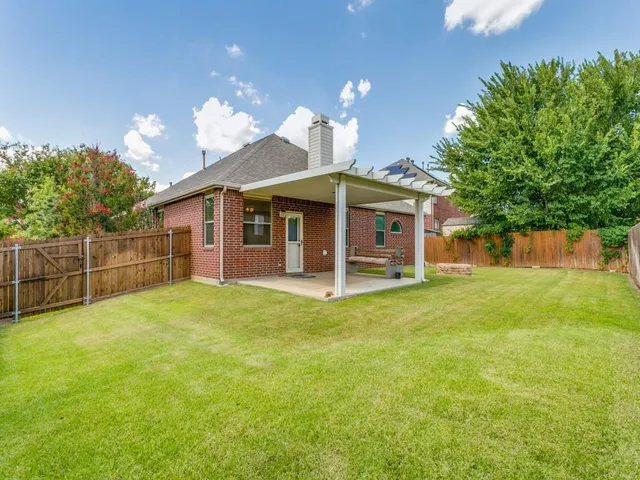 a view of a house with a yard and a patio