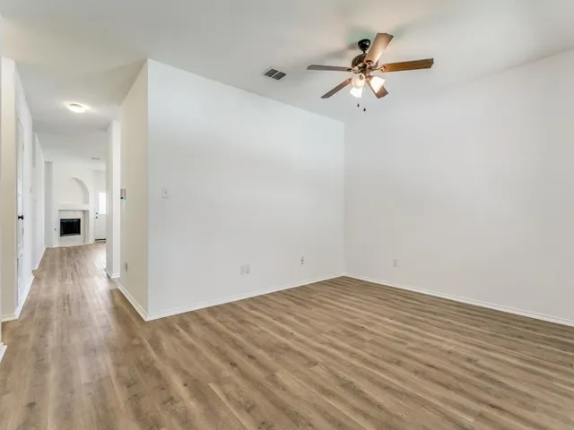 a view of a room with wooden floor and a ceiling fan
