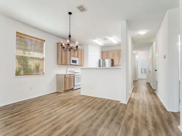 a view of a kitchen with wooden floor and a window
