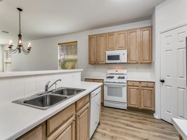 a kitchen with stainless steel appliances granite countertop a sink stove and cabinets
