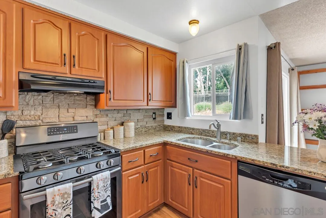 4021 Johnson Drive Oceanside, CA 92056 - Photo 12 of 25 a kitchen with granite countertop wooden cabinets and a stove top oven