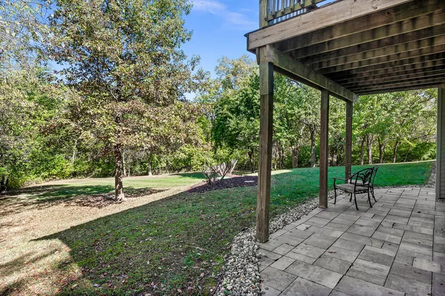 a kitchen with stainless steel appliances granite countertop a refrigerator a sink dishwasher a dining table and chairs with wooden floor