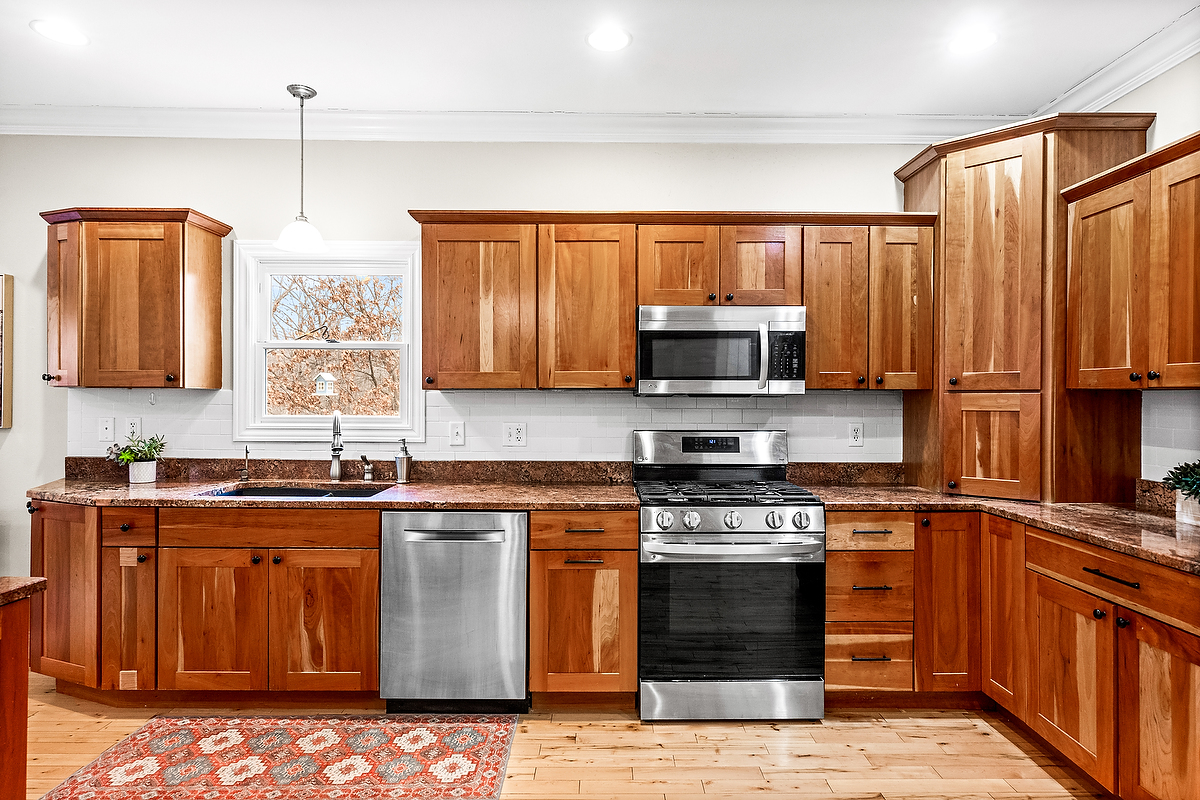 2296 Deer Ridge Court Carlock, IL 61725 - Photo 21 of 59 a kitchen with stainless steel appliances granite countertop a stove a sink dishwasher and a microwave oven with large wooden cabinets