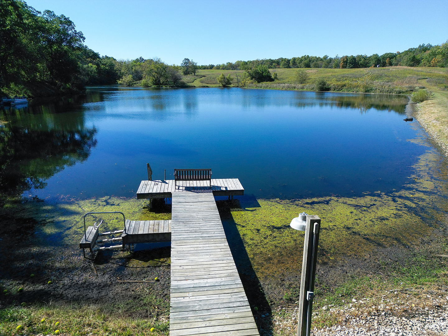 2296 Deer Ridge Court Carlock, IL 61725 - Photo 5 of 59 a view of a lake with lawn chairs and large trees