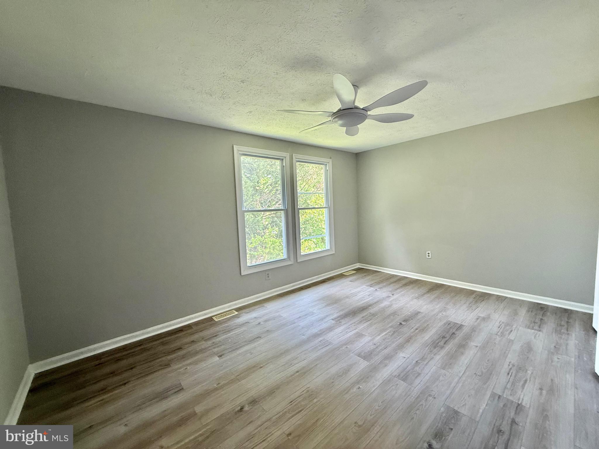 2 Cinnabar Court Gaithersburg, MD 20879 - Photo 32 of 46 an empty room with wooden floor fan and windows