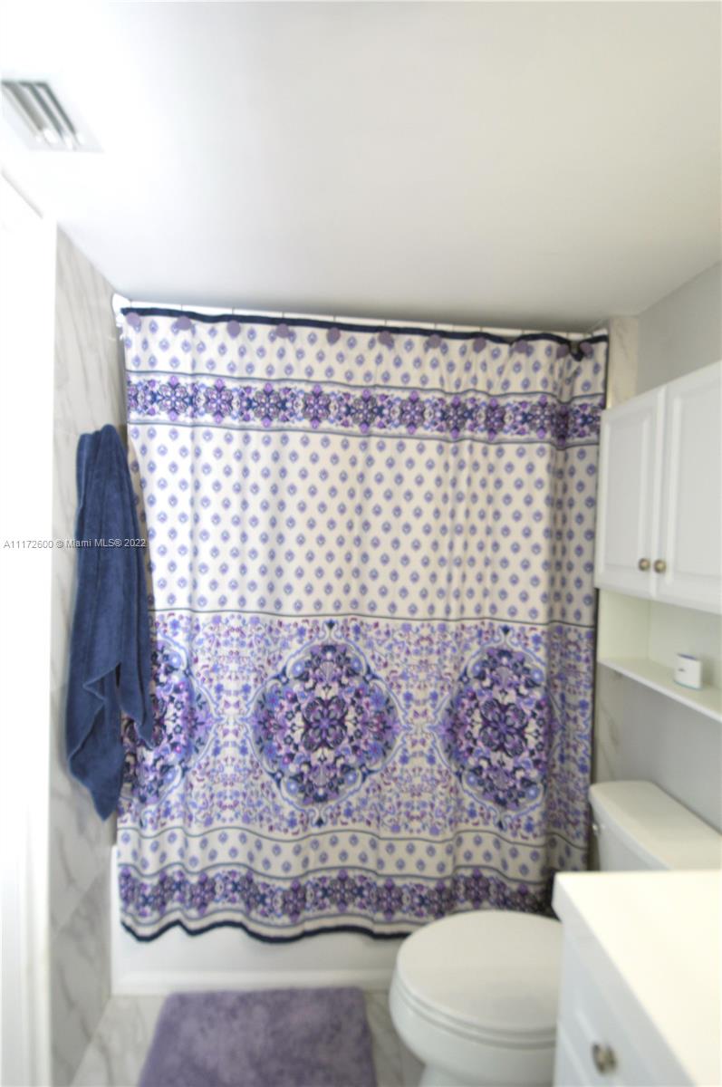 3000 Coral Way, Unit 521 Miami, FL 33145 - Photo 15 of 24 a bathroom with a toilet and a shower curtain