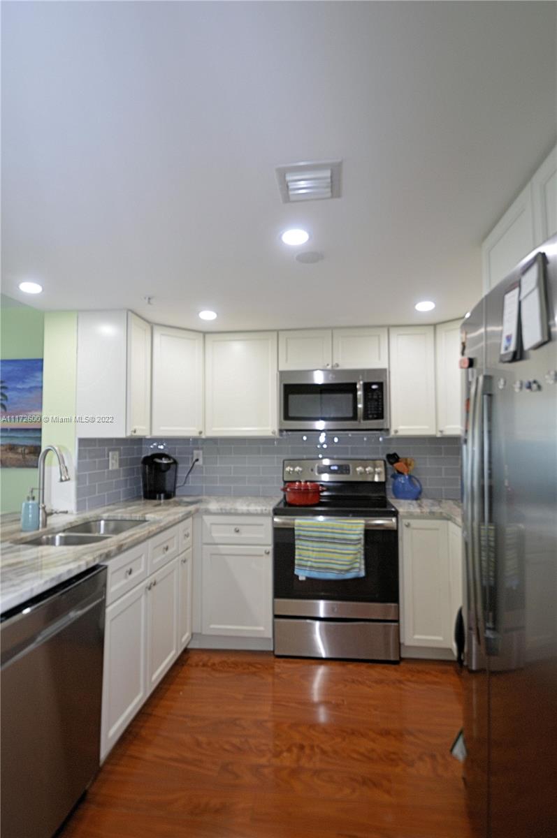 3000 Coral Way, Unit 521 Miami, FL 33145 - Photo 6 of 24 a kitchen with stainless steel appliances a sink a stove a refrigerator and a microwave