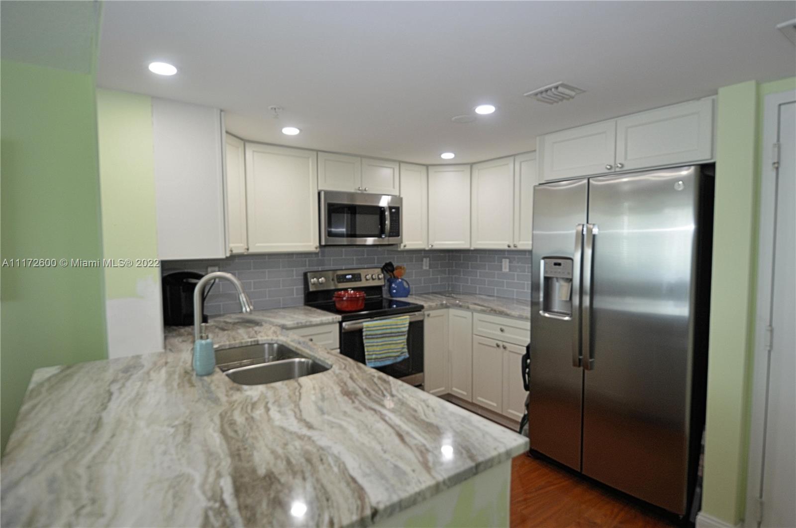 3000 Coral Way, Unit 521 Miami, FL 33145 - Photo 7 of 24 a kitchen with a refrigerator a microwave a sink and cabinets