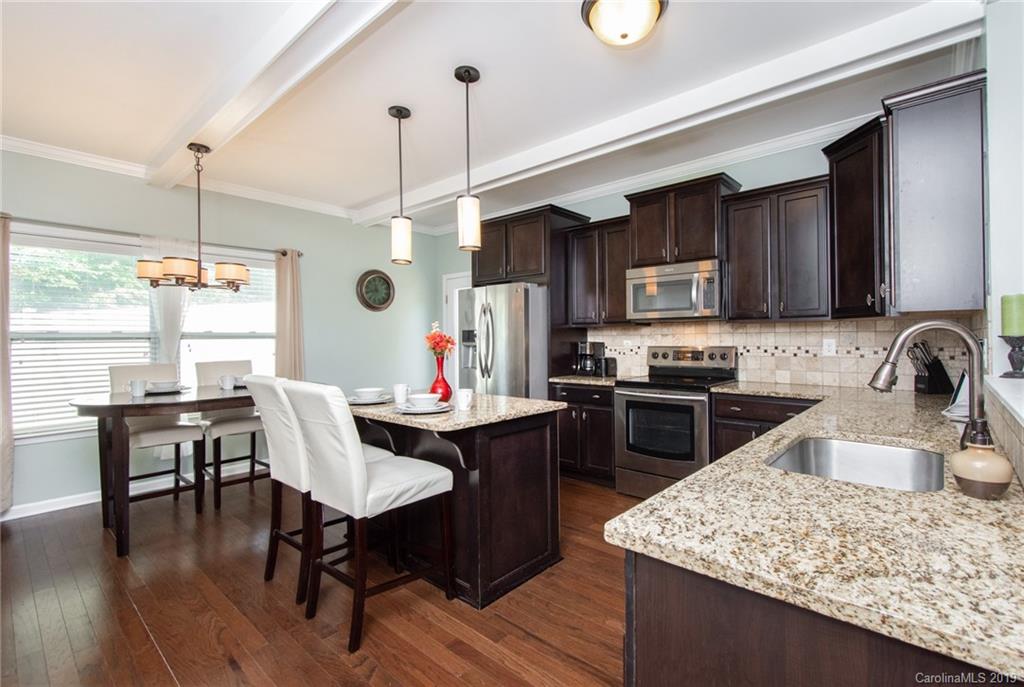 7059 Meyer Road Fort Mill, SC 29715 - Photo 12 of 30 a kitchen with a stove a sink a dining table and chairs