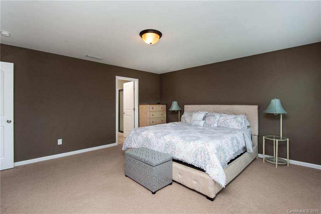 7059 Meyer Road Fort Mill, SC 29715 - Photo 16 of 30 a spacious bedroom with a bed and lamp