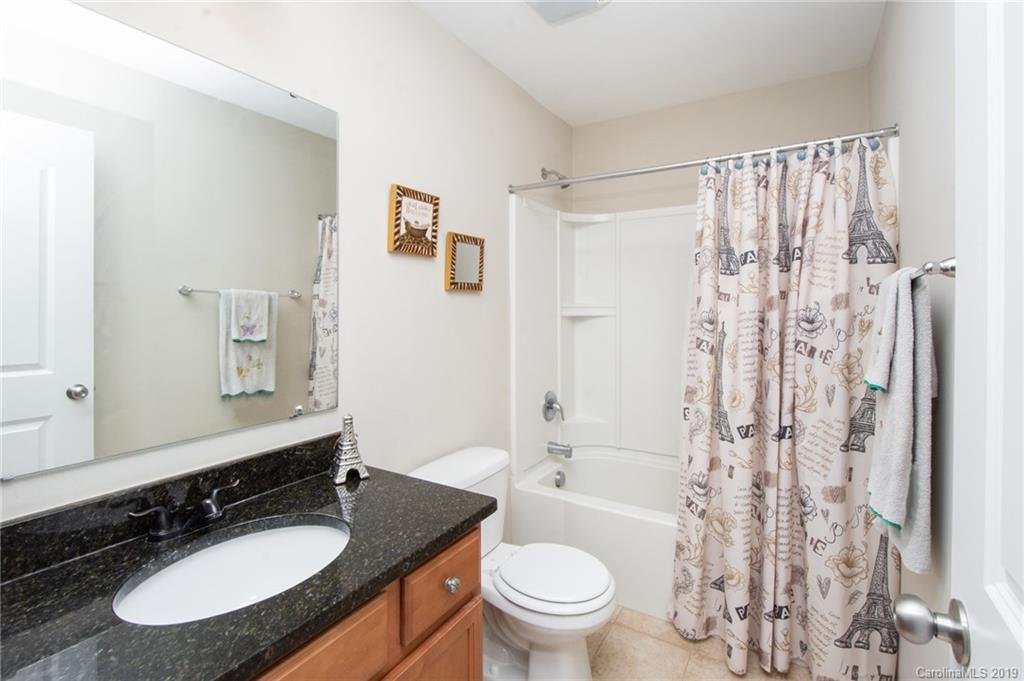 7059 Meyer Road Fort Mill, SC 29715 - Photo 22 of 30 a bathroom with a granite countertop sink toilet a mirror a shower and a mirror