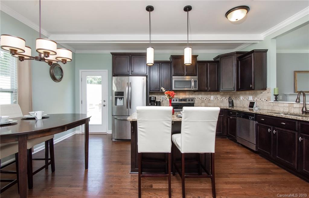 7059 Meyer Road Fort Mill, SC 29715 - Photo 10 of 30 a kitchen with a dining table chairs sink and cabinets