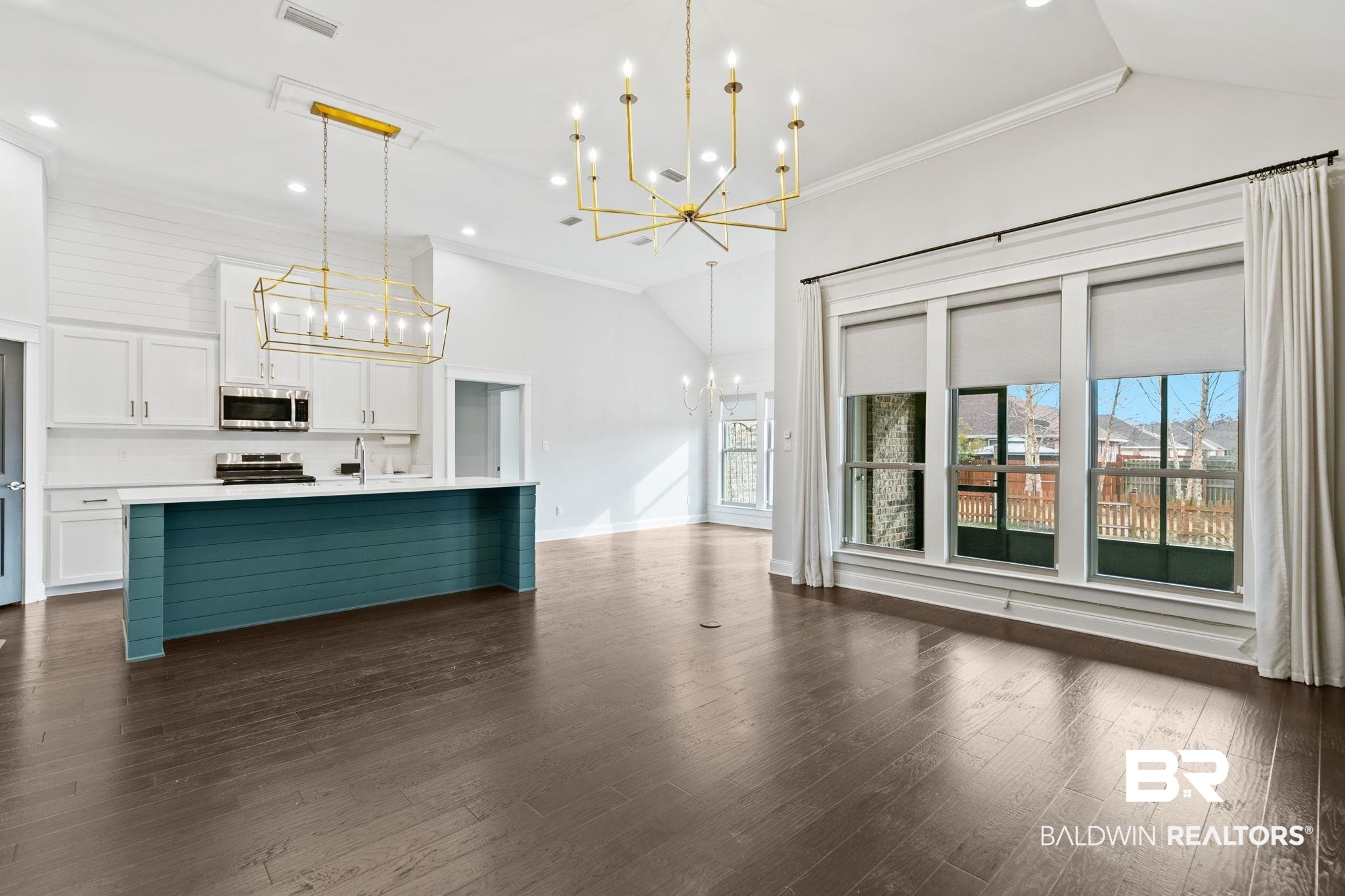 31654 Canopy Loop Daphne, AL 36527 - Photo 64 of 64 Dual tone kitchen featuring ornamental molding, lofted ceiling, a chandelier, open floor plan, and a center island with sink