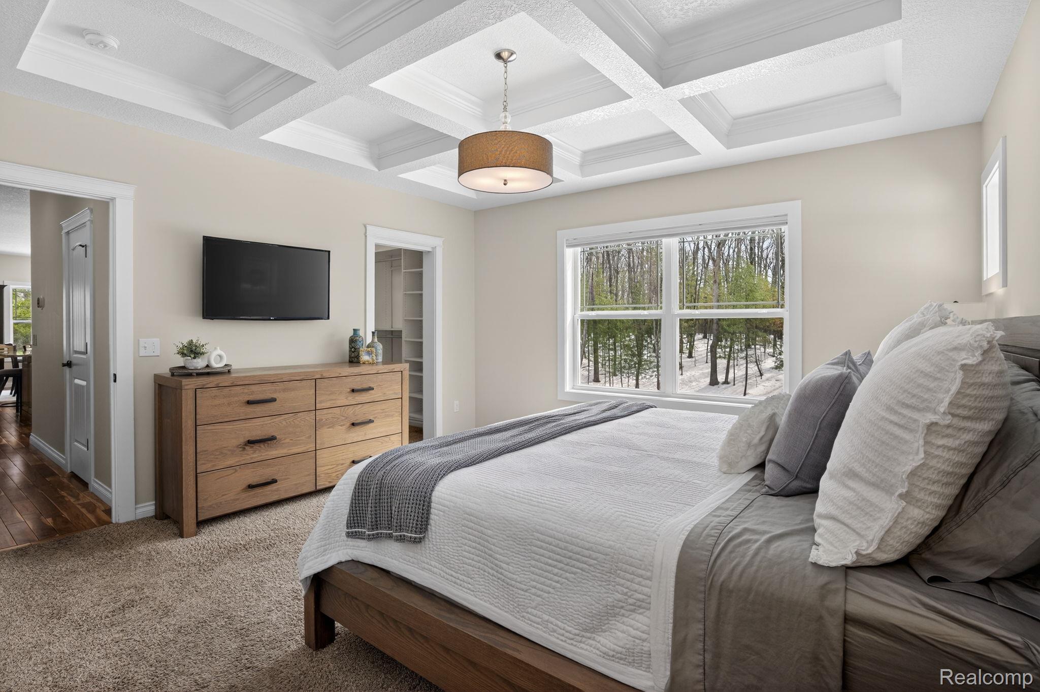 101 Highview Road Traverse City, MI 49696 - Photo 39 of 88 Bedroom with a walk in closet, coffered ceiling, carpet flooring, and ornamental molding