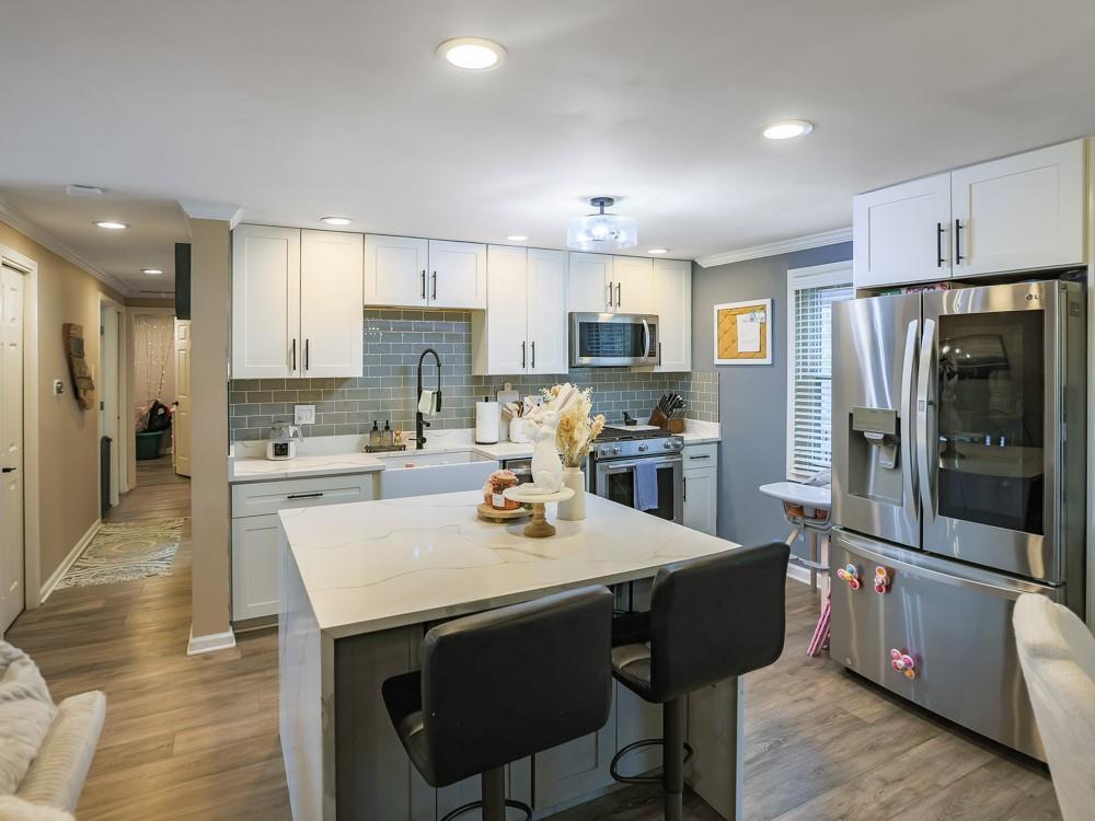 136 Ridgewood Drive Economy, PA 15042 - Photo 16 of 17 a kitchen with stainless steel appliances a stove a sink a refrigerator white cabinets and wooden floor