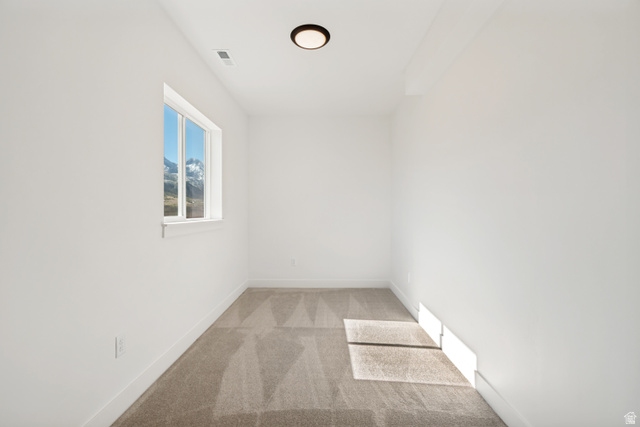 1351 Maple Circle Santaquin, UT 84655 - Photo 33 of 42 Bright room featuring a window with a mountain backdrop, neutral carpet flooring, white walls, and a ceiling-mounted light fixture