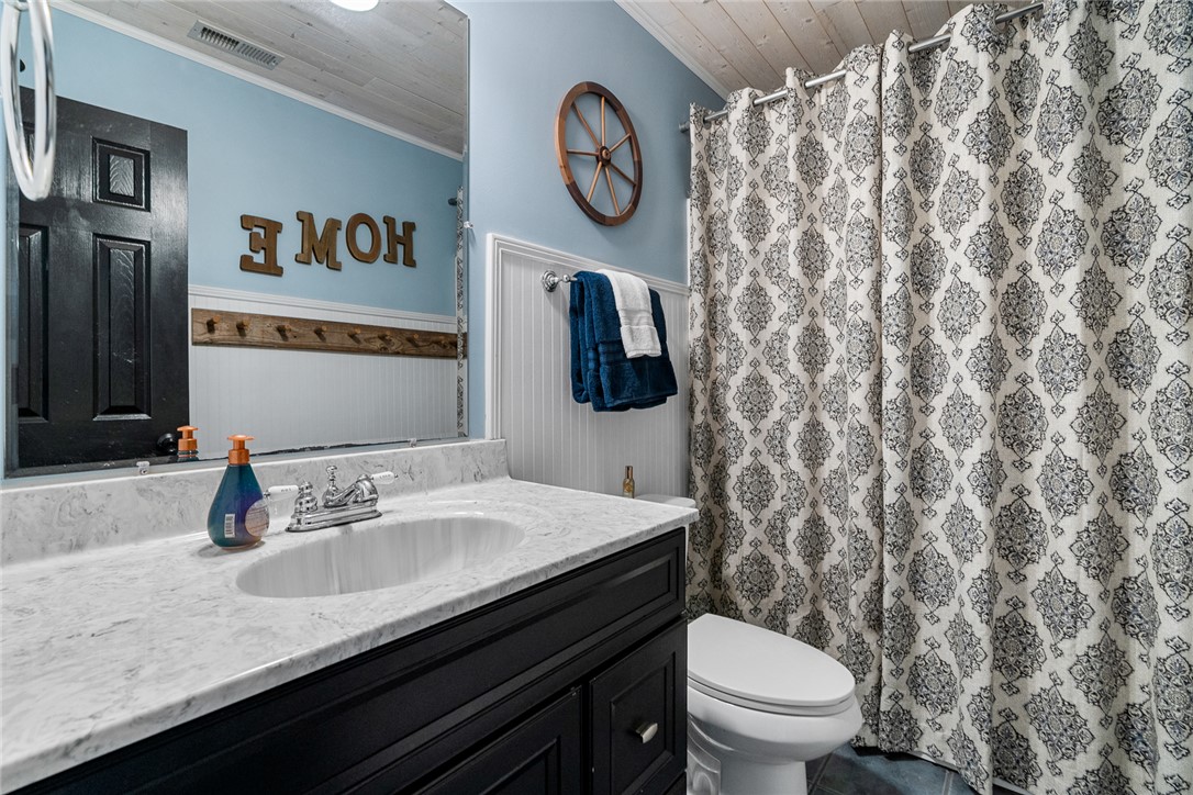 112 C-10-220 Anderson, SC 29621 - Photo 33 of 45 This bright bathroom features a single vanity, a toilet, and a patterned shower curtain.