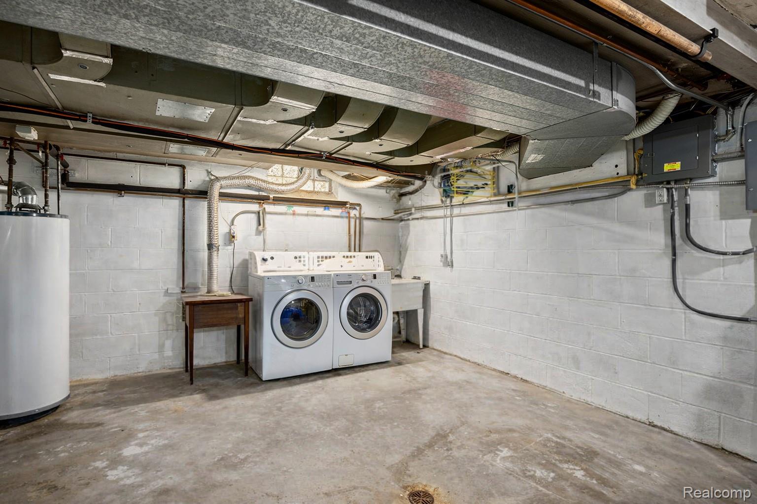 244 Kerby Road Grosse Pointe, MI 48236 - Photo 38 of 53 Unfinished below grade area featuring electric panel, water heater, and washing machine and clothes dryer