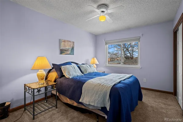 a bedroom with a bed a painting on the wall and a window