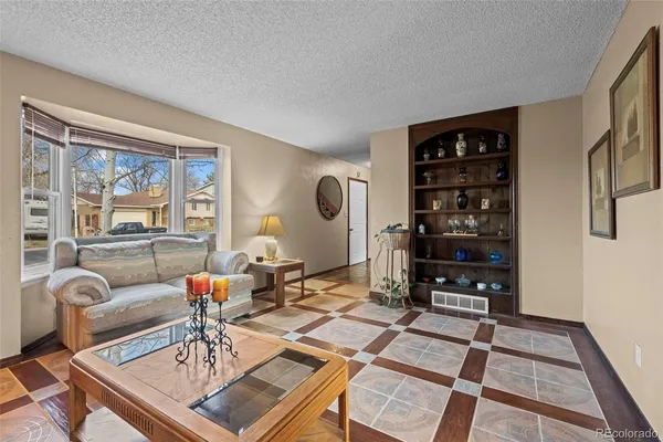 a living room with furniture a rug and bookshelf