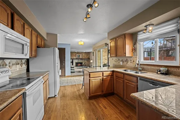 a kitchen with stainless steel appliances granite countertop a sink dishwasher stove and refrigerator