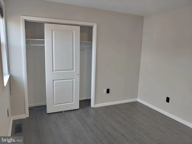 an empty room with wooden floor and closet