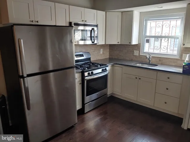 a kitchen with stainless steel appliances granite countertop a refrigerator a sink a stove a microwave and cabinets