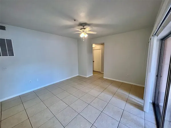 an empty room with closet and a chandelier fan