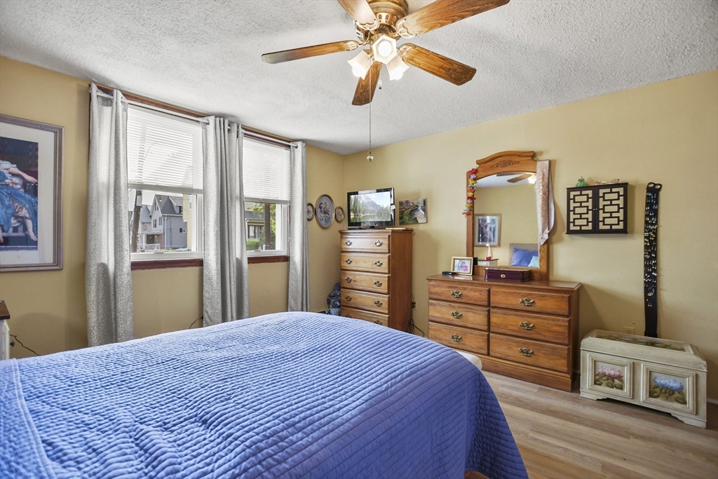 82 Cedar Street Everett, MA 02149 - Photo 13 of 41 a bedroom with a bed and wooden floor
