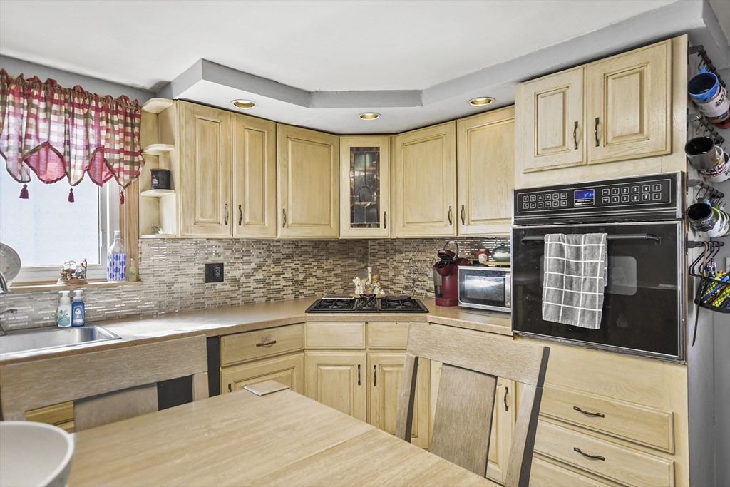 82 Cedar Street Everett, MA 02149 - Photo 27 of 41 a kitchen with stainless steel appliances white cabinets and a stove top oven