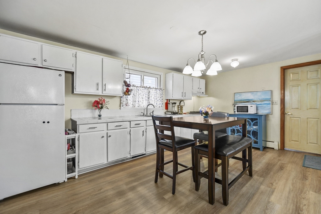 82 Cedar Street Everett, MA 02149 - Photo 4 of 41 a kitchen with a dining table chairs refrigerator and cabinets