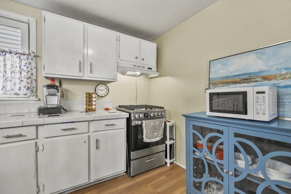 82 Cedar Street Everett, MA 02149 - Photo 6 of 41 a kitchen with stainless steel appliances white cabinets and a stove top oven