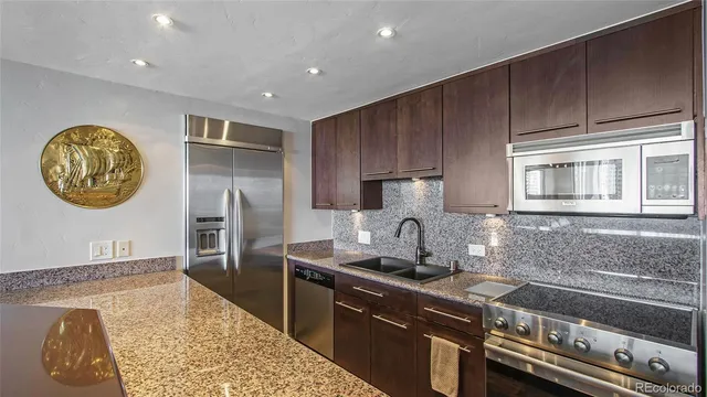 a kitchen with kitchen island granite countertop a stove and a refrigerator
