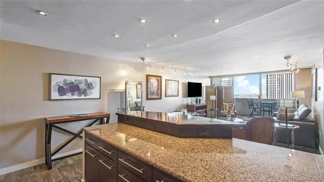 a living room with granite countertop furniture and a flat screen tv
