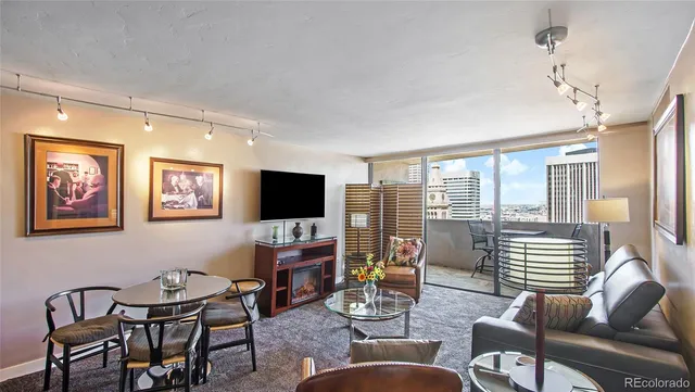 a living room with furniture a flat screen tv and a large window