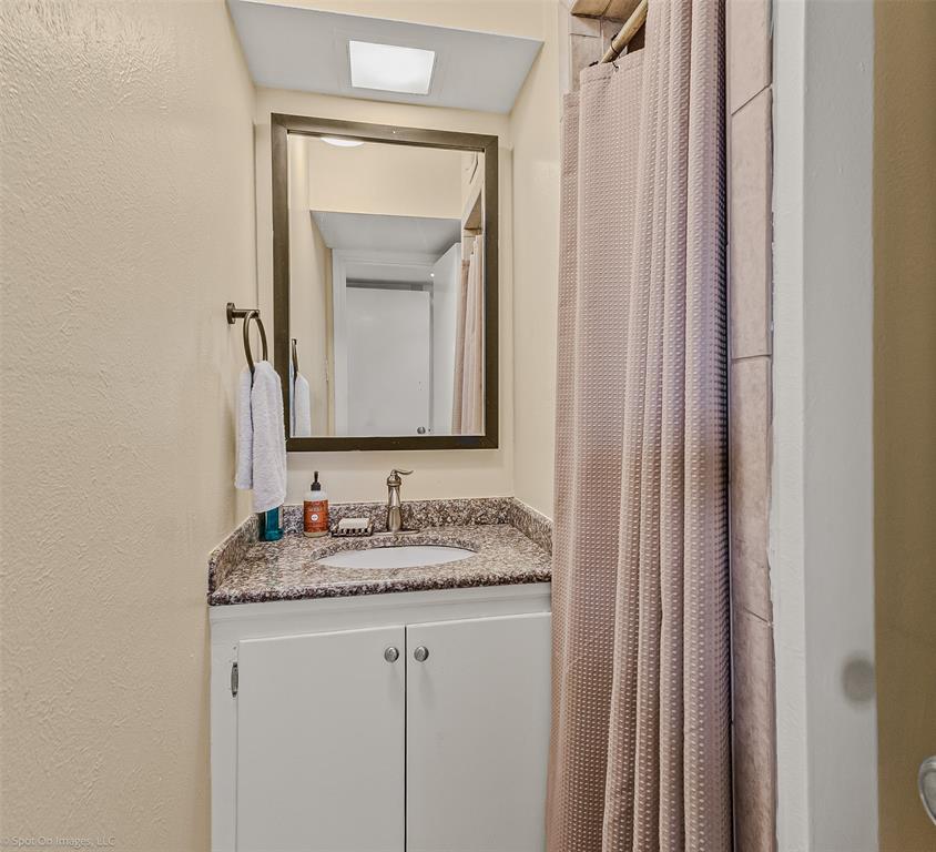 7910 Northaven Road, Unit B Dallas, TX 75230 - Photo 14 of 27 a bathroom with a granite countertop sink and a mirror