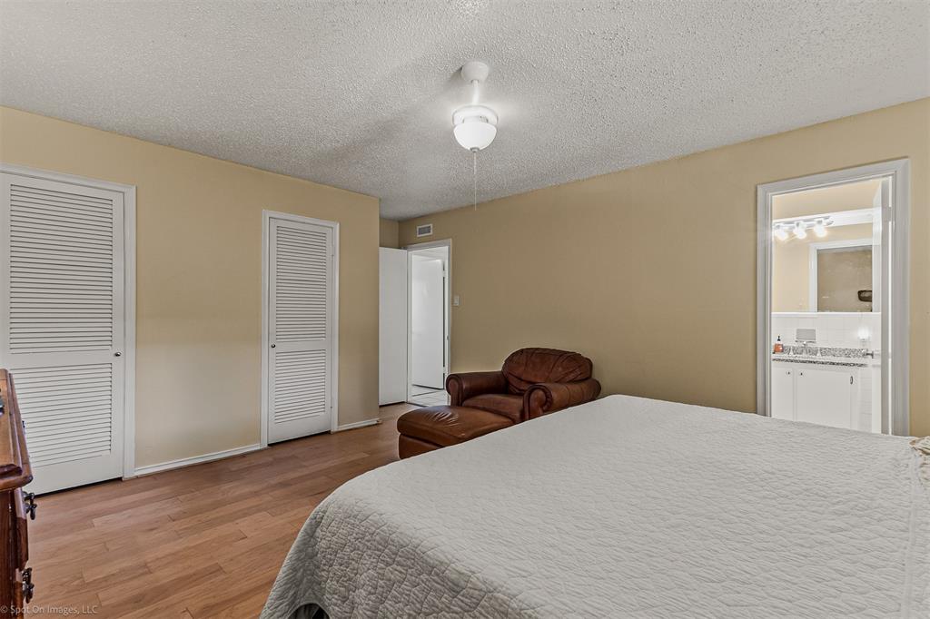 7910 Northaven Road, Unit B Dallas, TX 75230 - Photo 10 of 27 a bedroom with a bed and wooden floor