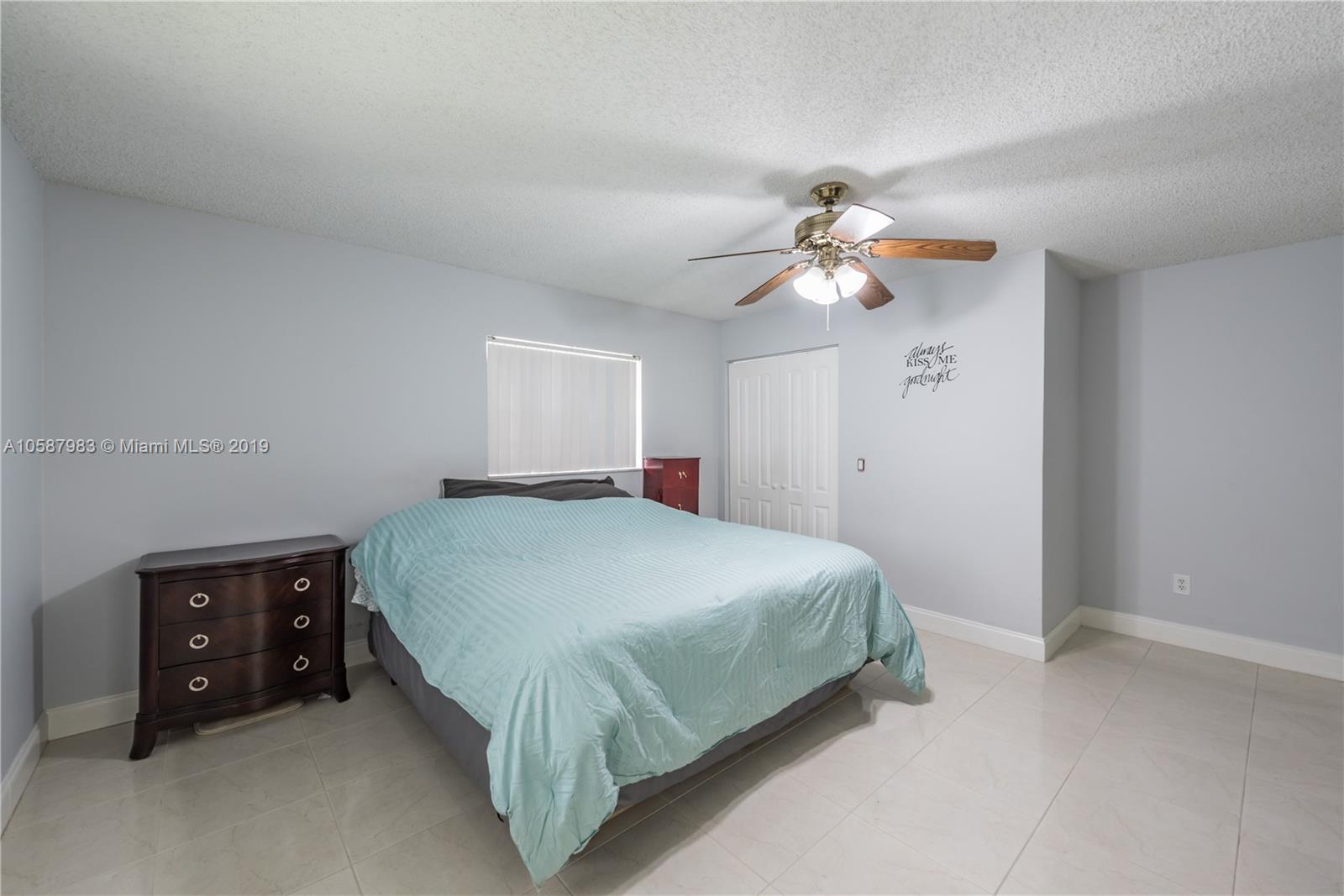 8912 Southwest 6th Street Boca Raton, FL 33433 - Photo 13 of 19 a bedroom with a bed and a chandelier