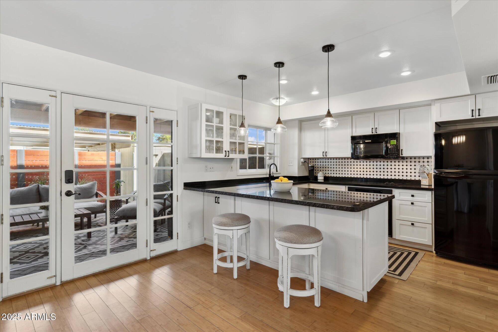 5020 North Granite Reef Road Scottsdale, AZ 85250 - Photo 2 of 24 a kitchen with stainless steel appliances granite countertop a stove top oven a sink a refrigerator white cabinets and wooden floor